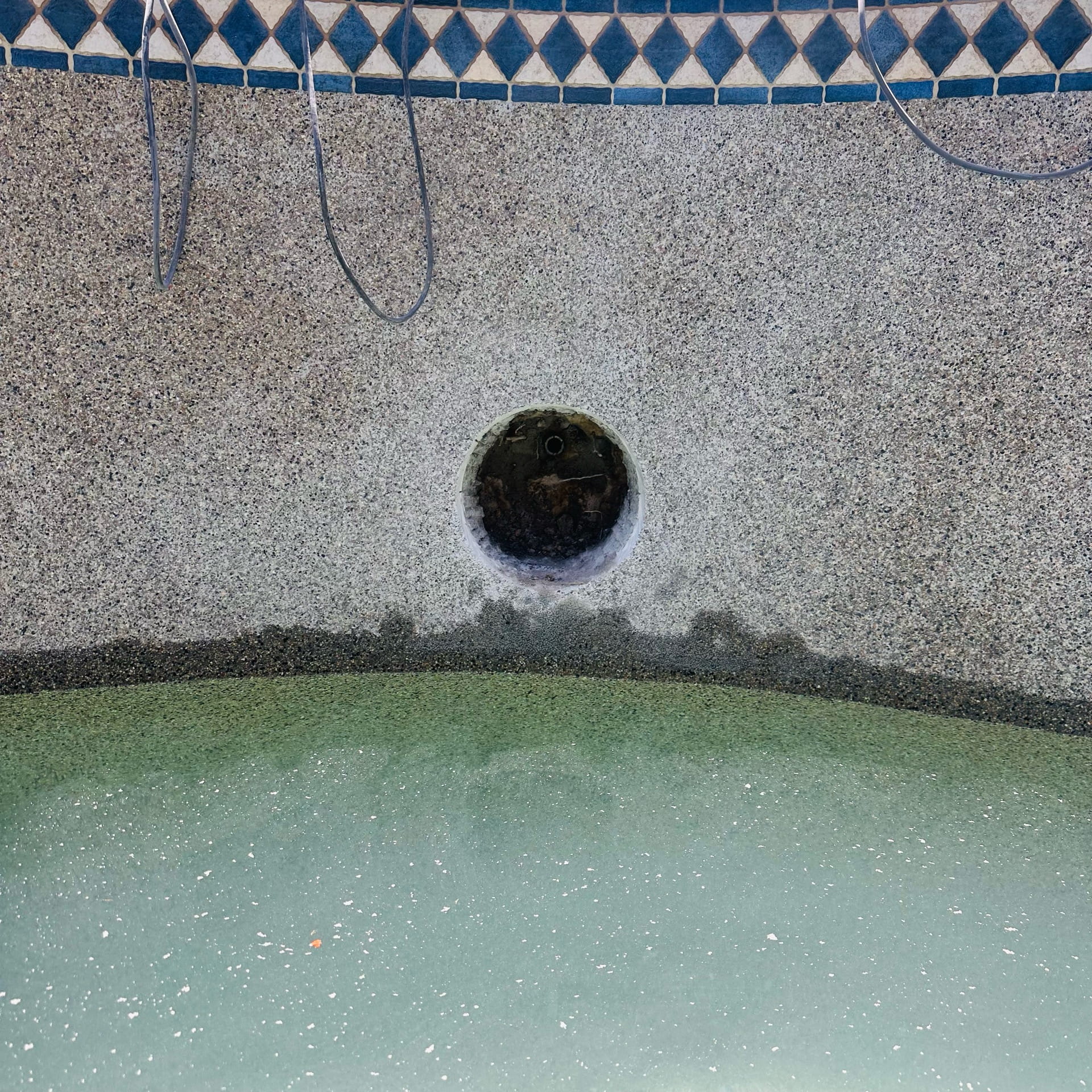 A leaking pool light niche being cut out for replacement.